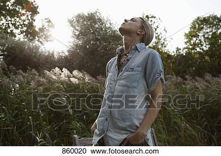 Stock Image - A woman enjoying the outdoors, non-urban scene. Fotosearch