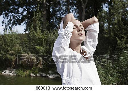 Stock Image - A woman relaxing in the sunlight. Fotosearch