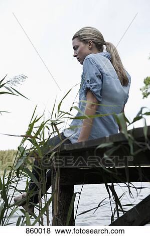 A woman relaxing on a jetty View Large Photo Image Stock Photo - A woman relaxing on a jetty. Fotosearch