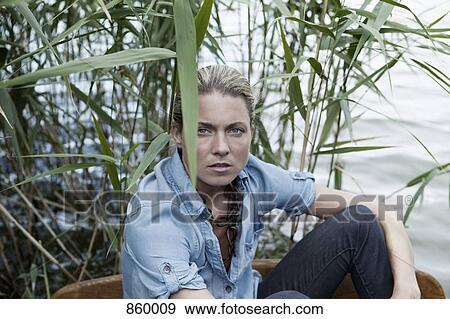 A woman sitting near water, portrait View Large Photo Image Stock Photo - A woman sitting near water, portrait. Fotosearch