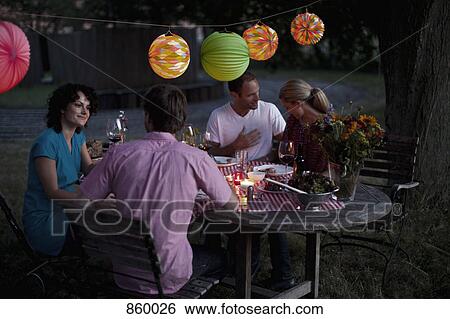 Stock Photograph - Four people at a dinner party. Fotosearch