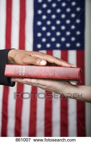Detail of a man swearing on the Bible View Large Photo Image Stock Photo - Detail of a man swearing on the Bible. Fotosearch