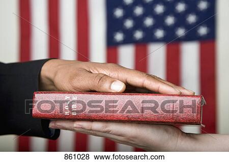 Stock Photo - Detail of a man swearing on the Bible. Fotosearch