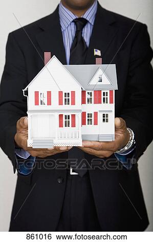Midsection of a man holding a model house View Large Photo Image Stock Photograph - Midsection of a man holding a model house. Fotosearch