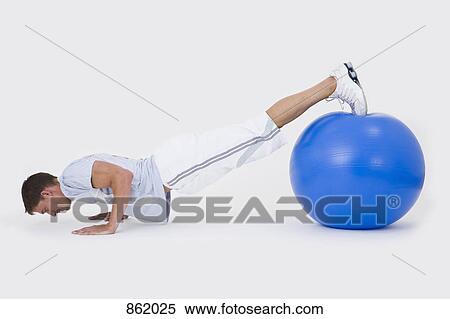 A man doing push-ups with an exercise ball View Large Photo Image Stock Photography - A man doing push-ups with an exercise ball. Fotosearch
