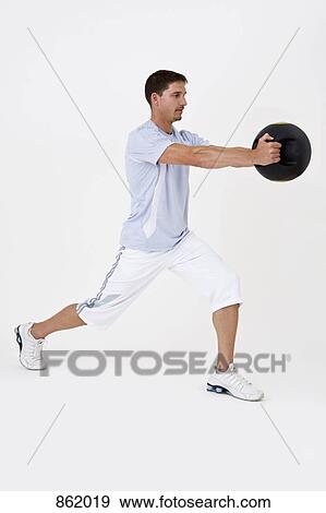 A man exercising with a medicine ball View Large Photo Image Stock Photo - A man exercising with a medicine ball. Fotosearch