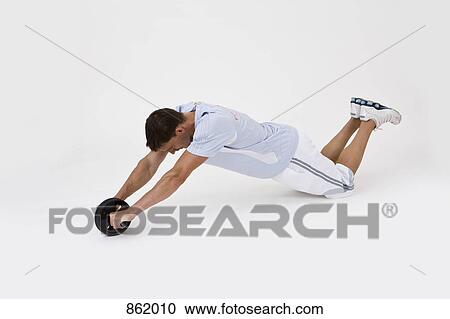 A man exercising with an abdominal wheel View Large Photo Image Stock Image - A man exercising with an abdominal wheel. Fotosearch