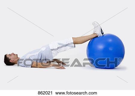 Stock Image - A man exercising with an exercise ball. Fotosearch