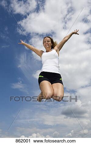 A woman jumping mid-air View Large Photo Image Stock Image - A woman jumping mid-air. Fotosearch
