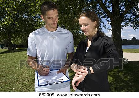 A woman with a personal trainer taking notes View Large Photo Image Stock Photo - A woman with a personal trainer taking notes. Fotosearch