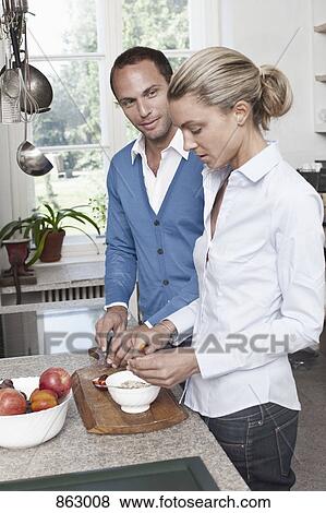A couple preparing food in the kitchen View Large Photo Image Stock Photo - A couple preparing food in the kitchen. Fotosearch