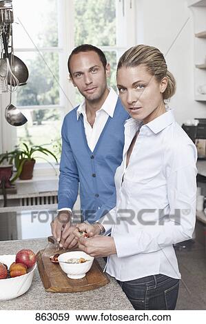 A couple preparing food in the kitchen View Large Photo Image Stock Photo - A couple preparing food in the kitchen. Fotosearch