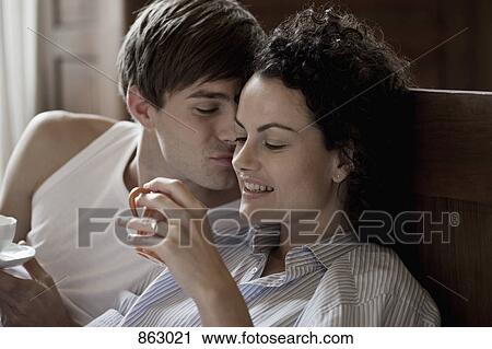 A couple sitting up in bed on a morning View Large Photo Image Stock Image - A couple sitting up in bed on a morning. Fotosearch