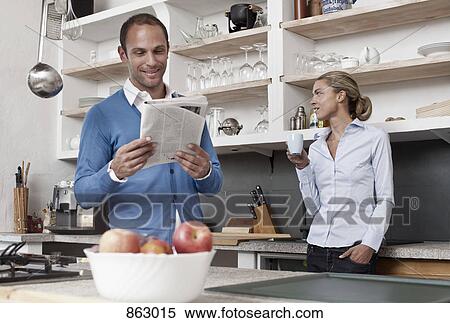 A couple standing in the kitchen View Large Photo Image Stock Photography - A couple standing in the kitchen. Fotosearch