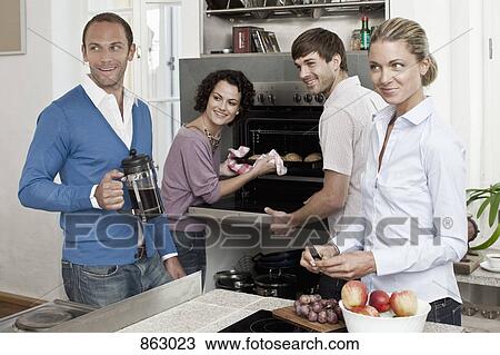 A group of friends preparing a meal in the kitchen View Large Photo Image Stock Image - A group of friends preparing a meal in the kitchen. Fotosearch