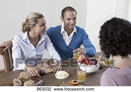 A group of friends sitting at the dining table together View Large Photo Image Stock Image - A group of friends sitting at the dining table together. Fotosearch
