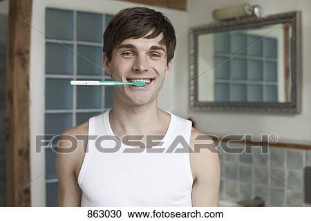 A man biting a toothbrush and smiling View Large Photo Image Stock Image - A man biting a toothbrush and smiling. Fotosearch