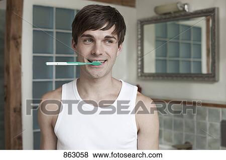 Stock Photo - A man biting a toothbrush. Fotosearch
