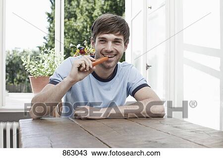 A man eating a carrot View Large Photo Image Stock Image - A man eating a carrot. Fotosearch