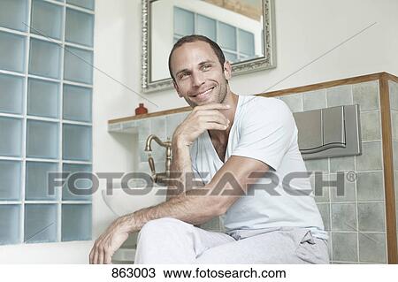 A man sitting in his bathroom View Large Photo Image Stock Image - A man sitting in his bathroom. Fotosearch