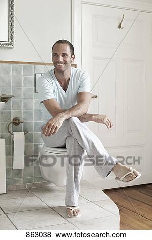 A Man Sitting On The Toilet In The Bathroom Stock Photo 863038