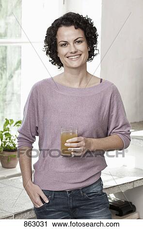 A woman holding a glass of juice View Large Photo Image Stock Image - A woman holding a glass of juice. Fotosearch