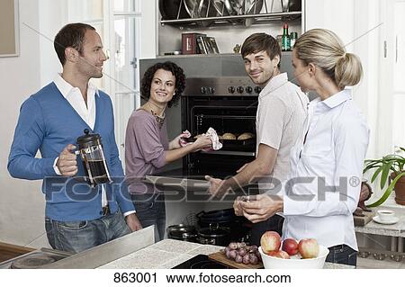 Four friends in the kitchen together View Large Photo Image Stock Image - Four friends in the kitchen together. Fotosearch