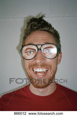 Stock Image - A man wearing novelty glasses and smiling. Fotosearch