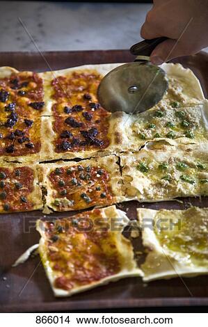 Picture - Detail of a pizza being cut. Fotosearch