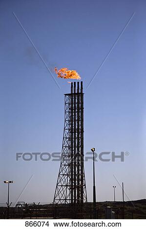 Picture - Flame burning above pipes at a fuel refinery, Karatha, Western Australia, Australia. Fotosearch