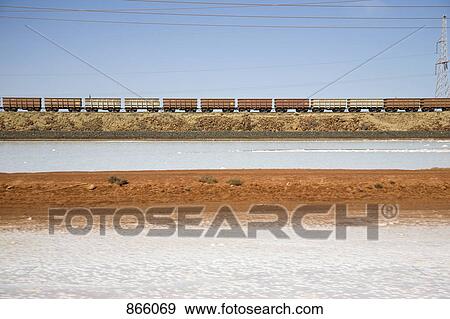 Freight train moving through a barren landscape View Large Photo Image Stock Photo - Freight train moving through a barren landscape. Fotosearch