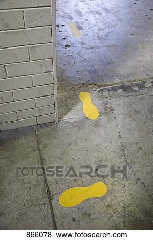 Stock Photo - Painted footprints on a concrete pathway. Fotosearch