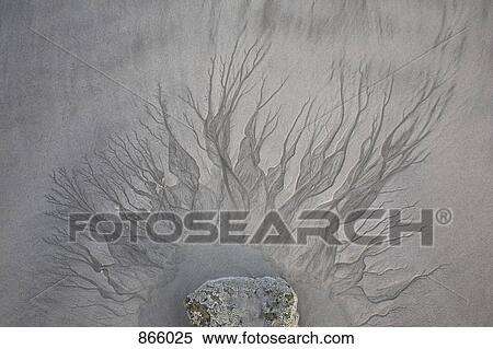 Stock Photography - Patterns in sand from water flowing from a puddle. Fotosearch