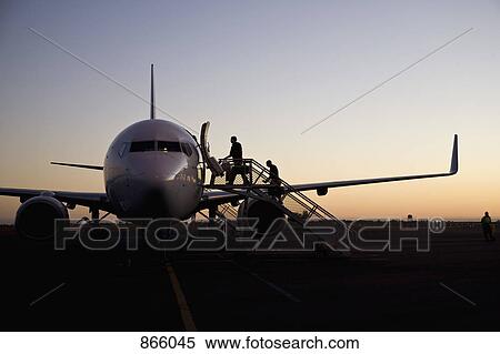 People boarding an airplane at dusk View Large Photo Image Stock Photography - People boarding an airplane at dusk. Fotosearch