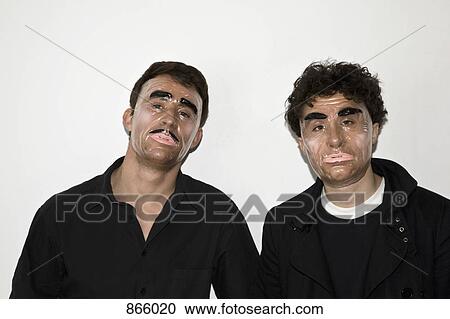 Stock Image - Two men posing in novelty masks. Fotosearch