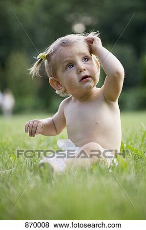 A baby girl sitting on grass in a diaper View Large Photo Image Stock Photo - A baby girl sitting on grass in a diaper. Fotosearch