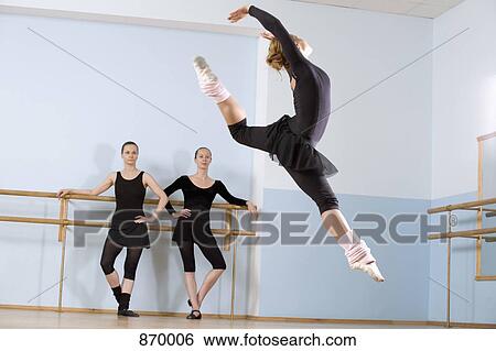 A ballerina leaping through the air as two other women look on View Large Photo Image Stock Photograph - A ballerina leaping through the air as two other women look on. Fotosearch