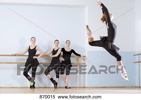 A ballerina leaping through the air as three other women look on View Large Photo Image Stock Photography - A ballerina leaping through the air as three other women look on. Fotosearch