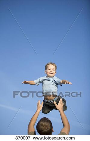 A boy being thrown into the air by a man View Large Photo Image Stock Photo - A boy being thrown into the air by a man. Fotosearch