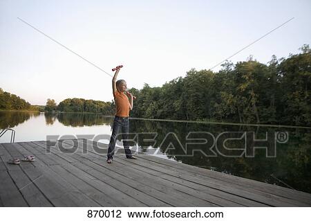A girl lifting hand weights on a wooden jetty View Large Photo Image Stock Image - A girl lifting hand weights on a wooden jetty. Fotosearch