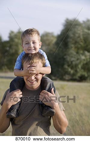 A man carrying a boy on his shoulder's View Large Photo Image Stock Image - A man carrying a boy on his shoulder's. Fotosearch