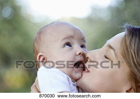 Stock Image - A mother kissing her baby boy. Fotosearch