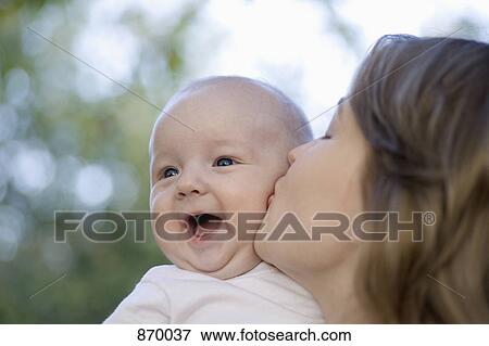 Stock Photo - A mother kissing her baby boy. Fotosearch