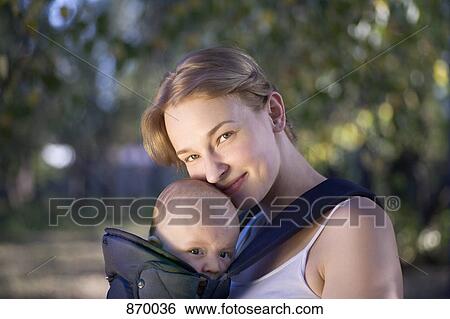 A mother with her baby in a baby carrier, portrait View Large Photo Image Stock Photograph - A mother with her baby in a baby carrier, portrait. Fotosearch