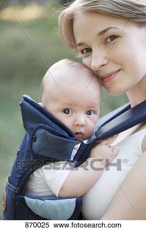 A mother with her baby in a baby carrier, portrait View Large Photo Image Stock Photography - A mother with her baby in a baby carrier, portrait. Fotosearch