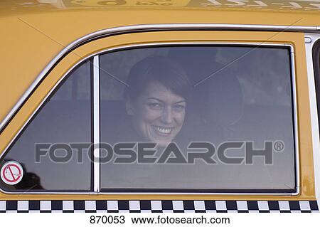 Stock Image - A woman in a taxi smiling. Fotosearch