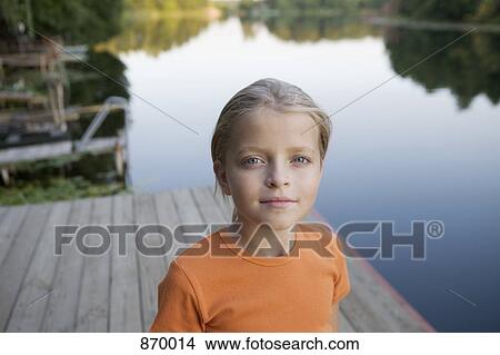 Portrait of a young girl standing on a wooden jetty View Large Photo Image Picture - Portrait of a young girl standing on a wooden jetty. Fotosearch