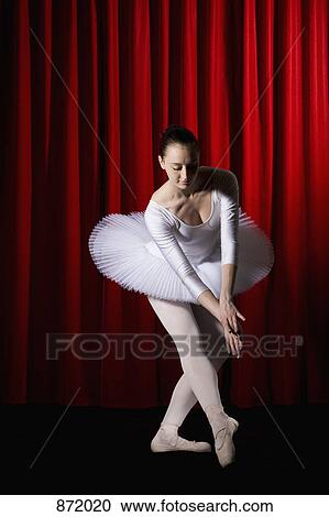 Stock Image - A ballet dancer posing on a stage. Fotosearch