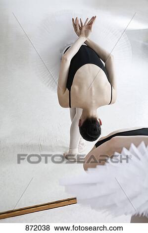 Stock Photo - A ballet dancer practicing in front of a mirror. Fotosearch