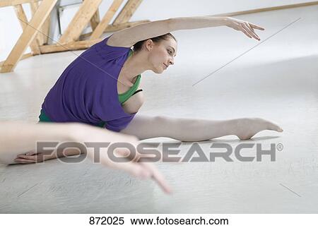 A ballet dancer stretching in front of a mirror in a ballet studio View Large Photo Image Stock Photography - A ballet dancer stretching in front of a mirror in a ballet studio. Fotosearch